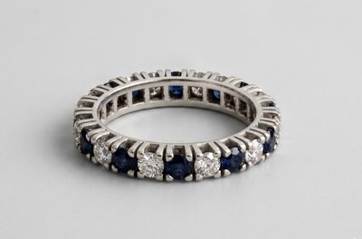 a close up of a white gold ring with blue sapphires and diamonds