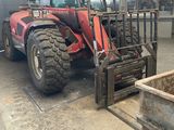 a red tractor that is parked in a garage