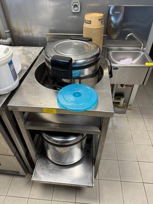 une cuisine équipée d'une cuisinière, d'un évier et de casseroles posées sur le plan de travail