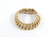 gros plan d'un bracelet en or sur une surface blanche