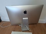 a silver apple computer sitting on a wooden floor