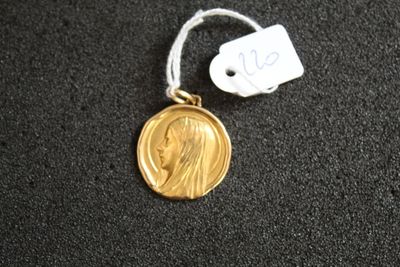 une médaille d'or avec la photo d'une femme dessus