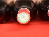 several bottles of wine are lined up on a red surface