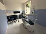 an image of a dentist ' s office with a chair and desk
