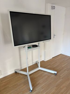 un téléviseur à écran plat posé sur un support dans le coin d'une pièce