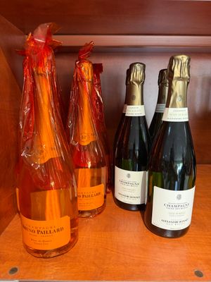 plusieurs bouteilles de vin sont alignées sur une étagère