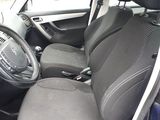 the interior of a small car with black seats and a steering wheel