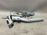 a silver and black hair dryer and a charger on a table