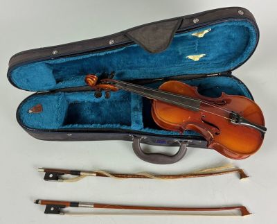 a violin in a case with a bow and other musical instruments