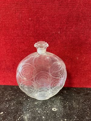 an empty glass bottle sitting on top of a black counter