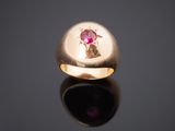 un gros plan d'une bague en or ornée d'un rubis au centre