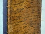 un vieux livre posé sur une table couverte de terre