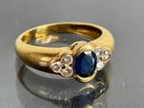 une photo en gros plan d'une bague en or sertie d'un saphir et de diamants