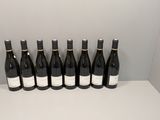 six bouteilles de vin sont alignées sur une étagère blanche