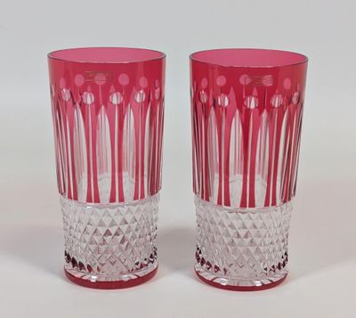 une paire de vases en verre rose posés sur une surface blanche, sur fond blanc