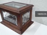 a small wooden clock with a glass case on a table