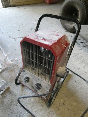 un petit radiateur portable posé par terre dans un garage