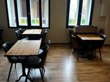 une pièce équipée de tables et de chaises et dotée de fenêtres