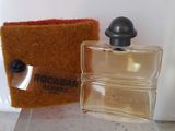 un petit flacon de parfum à côté d'un petit sac