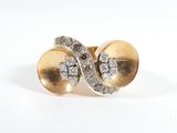une photo représentant une paire de boucles d'oreilles en or et diamants posées sur une surface blanche