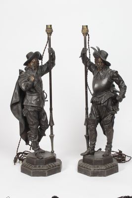 paire de figurines anciennes en bronze représentant un homme et une femme tenant des torches
