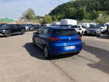 a blue car parked in a parking lot next to other cars