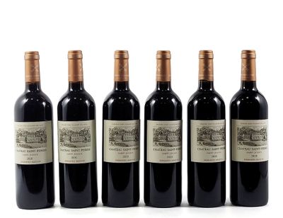 four bottles of wine are lined up on a white surface