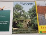 three books on a shelf with a picture of a river and a bridge