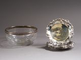 a silver bowl and a silver plate on a table