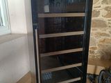 a wine cooler that is sitting on the floor next to a window