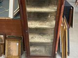 une vitrine en verre surmontée d'une horloge, dans une pièce
