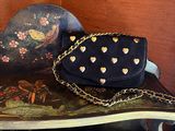 a black purse sitting on top of a wooden shelf