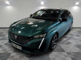 La voiture verte est garée sur un sol à damier dans le garage.