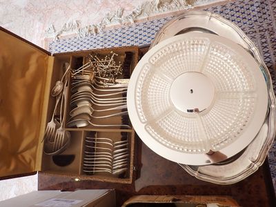 beaucoup d'argenterie dans une boîte posée par terre