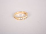 a close up of a gold ring with diamonds on a white surface