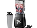 the blender is black and has a blender with berries in it