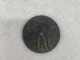 a small bronze coin with a man and a woman on it