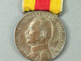 an image of a medal with a red, yellow, and red ribbon
