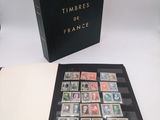an open book with stamps on it sitting on top of a table