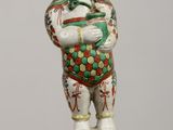 chinese porcelain figurine of a boy holding a bowl of fruit