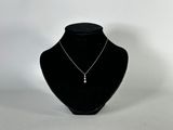 mannequin en velours noir portant un collier argenté, sur fond blanc