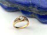 une image représentant une bague en diamant posée sur une pierre bleue