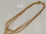a gold necklace with three strands of gold beads on a white background