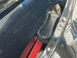 a black car with a red object in it ' s trunk