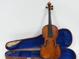 un vieux violon dans son étui, posé sur une surface blanche