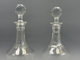 pair of clear glass decanters on a grey background