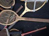 several tennis rackets are lined up on a black surface