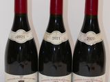 trois bouteilles de vin rouge sont alignées sur une table