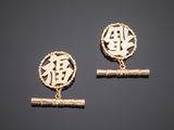 a pair of gold earrings with chinese characters on them