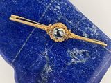 a close up of a blue stone with a gold tie bar